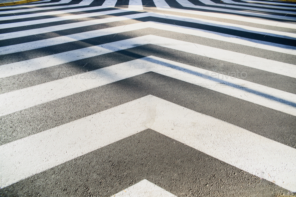 White converging lines on a black asphalt background in an unusual crosswalk. - Stock Photo - Images