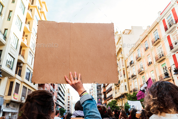 Women during a feminist protest holding blank, empty banners to fill in with text.