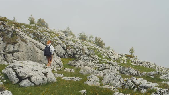 Caucasian girl walking on a rocky hiking path. alt