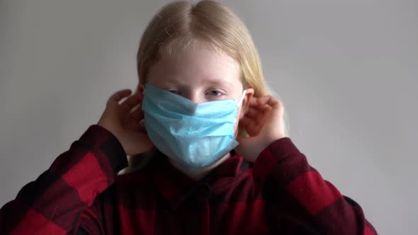 Protection Against Coronavirus. Girl Puts a Mask on Her Face