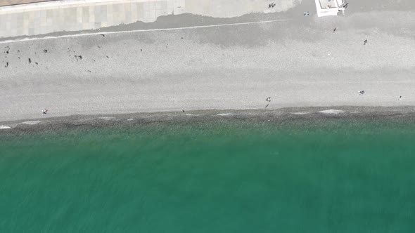 Aerial View of People Crowd Relaxing on Beach and Sea with Waves alt