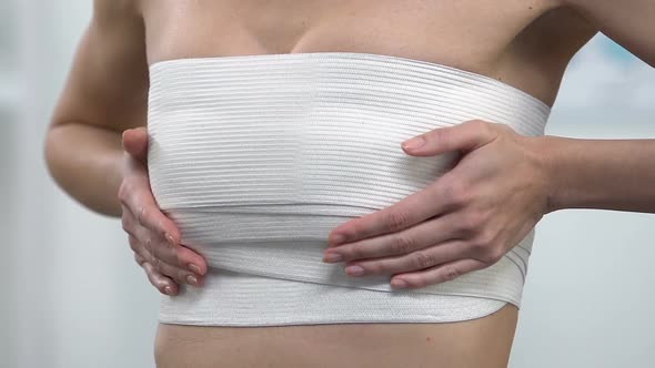 Female Patient Touching Breast in Chest Compression Wrap, Lifting Surgery alt
