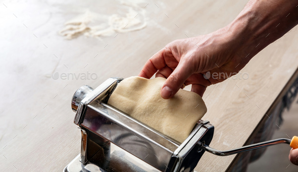 Fresh pasta maker machine. Dough homemade preparation. Hand make