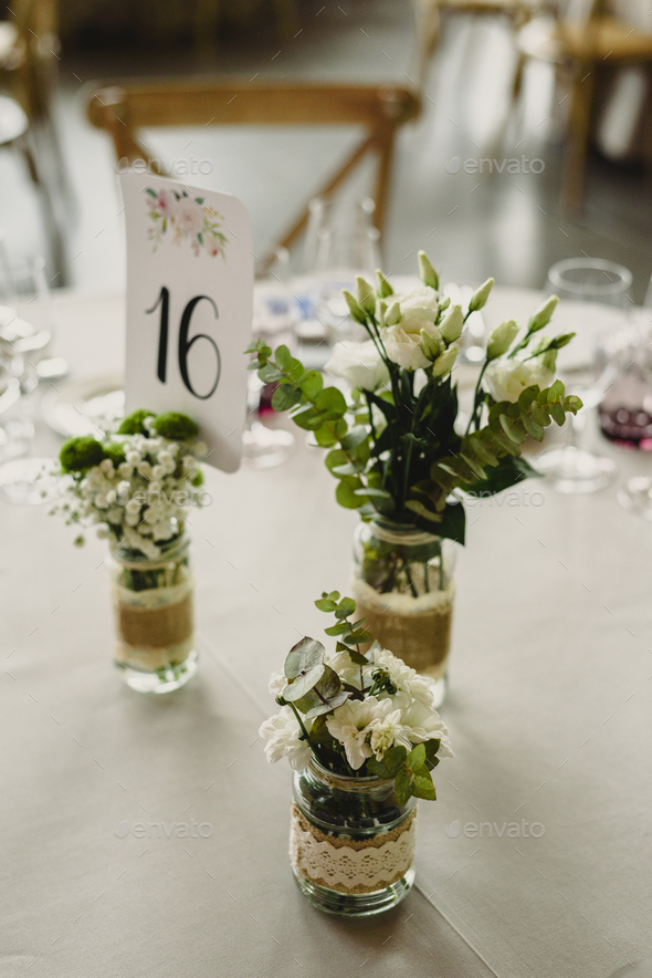 Centerpieces in a wedding hall, floral decorations photographed during the day.