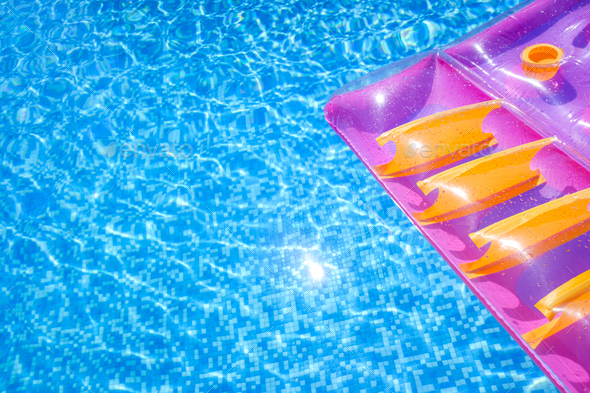 Transparent water from a pool, background with summer colored floats ...