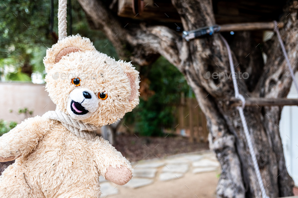 Strange and scary image, a teddy bear hanged with a neck rope.