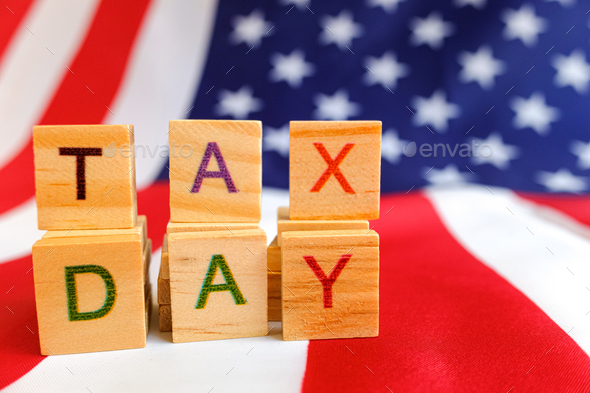 Tax day written with wooden letters to indicate the day of payment of taxes in america.
