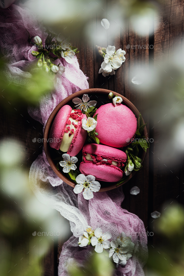 Top view on pink macaron cookies on wooden brown background with apple blossom - Stock Photo - Images