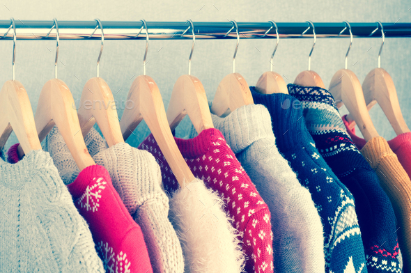 Warm sweaters. Female clothes on open clothes rail. Sale and shopping concept