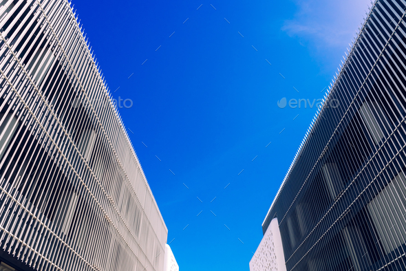 Two buildings converging on a blue sky background in the center. - Stock Photo - Images