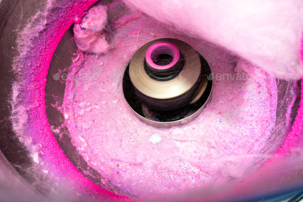 Machine to make cotton candy by turning and toasting the pink sugar.
