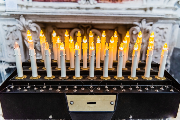 Electronic candles with LEDs in a church to make an offering of alms.