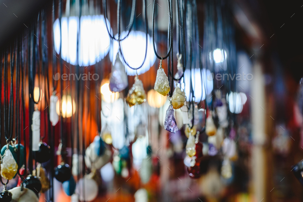 Quartz and other precious stones hung on necklaces in a mineral and beauty shop.