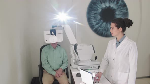 Optometrist Using Eye Chart Projector For Checkup alt