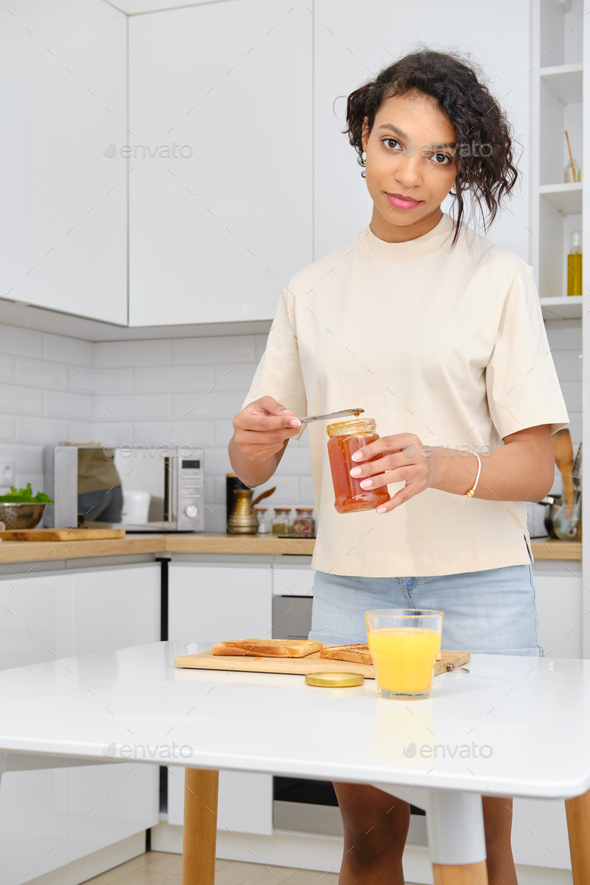African american woamn holds apricot jam in hand