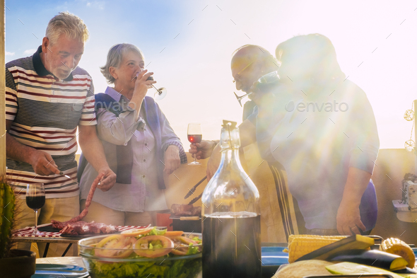 Group of old people friends enjoy leisure together with food and drinks. Grill bbq activity