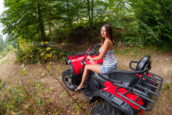 Beautiful girl driving four-wheeler ATV