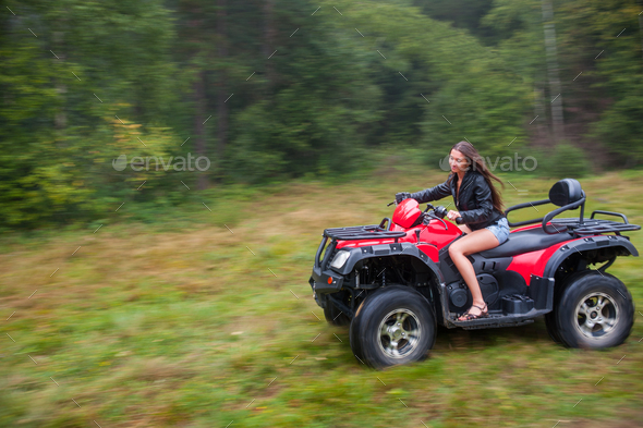 Beautiful girl driving four-wheeler ATV