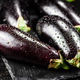 Fresh ripe eggplant with droplets of water on a stone board. - PhotoDune Item for Sale