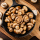 Fried mushrooms in a frying pan on a cutting board. - PhotoDune Item for Sale