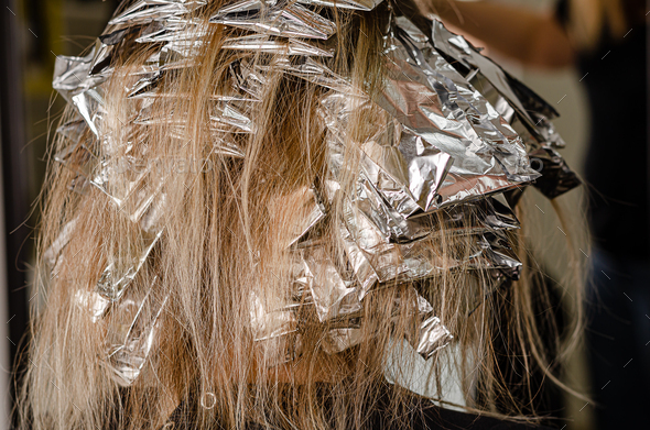 Foil on models hair. Bleaching or dyeing process.