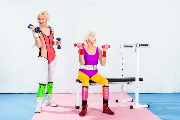 athletic young women in 80s style sportswear posing together on grey Stock  Photo by LightFieldStudios