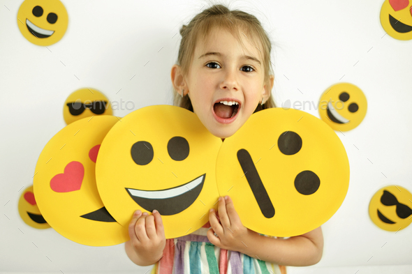 Human holds emoticons with different emotions in her hands - Stock Photo - Images