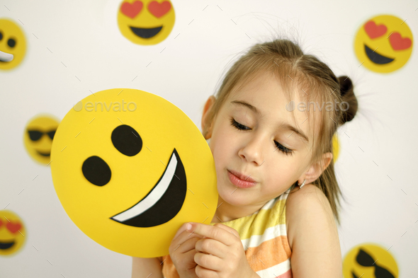 Person looks curiously at the happy emoticon. - Stock Photo - Images