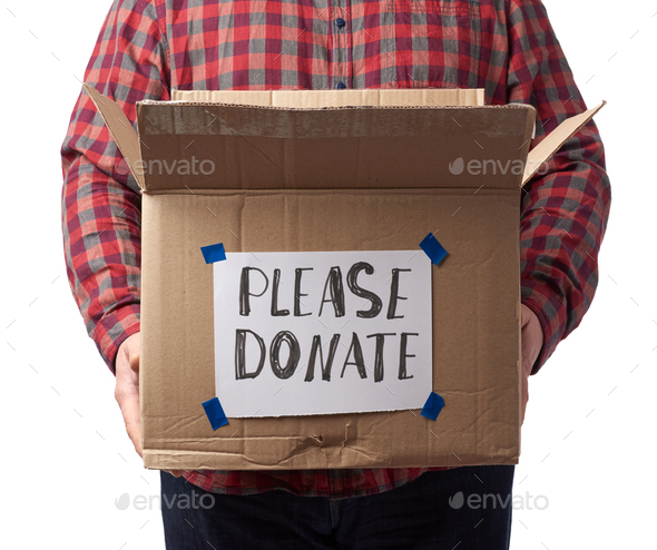 Man in a plaid shirt and jeans holds a brown cardboard box with the inscription please donate