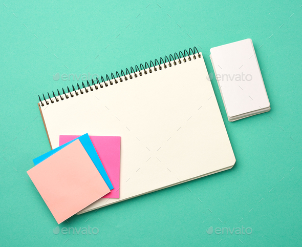 Open notebook with blank white sheets, color stickers and rectangular business cards