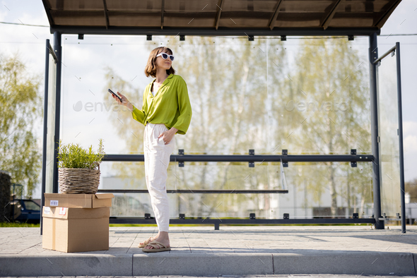 Woman with parcels and flowerpot on a bus stop
