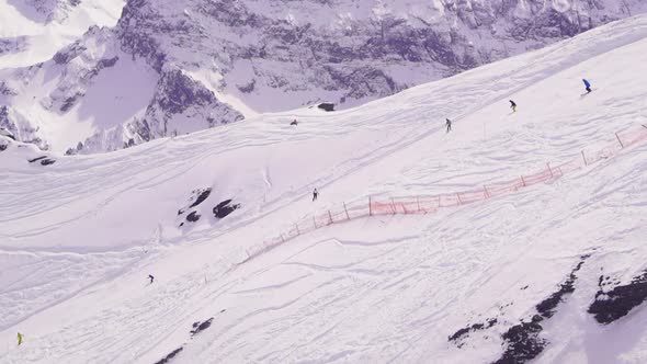 Skiers freeride down hill on a snowboard.