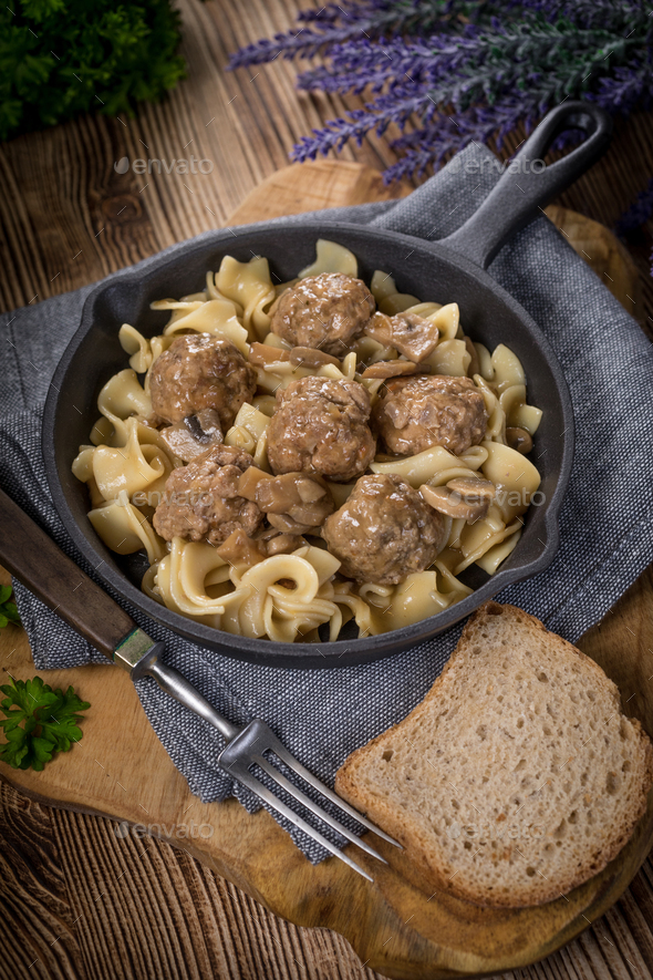 Pork meatballs with noodles in a cast iron skillet. Stock Photo by foto_pstryki