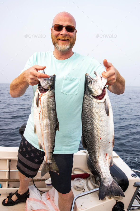 Fisherman holding fresh catch Coho salmon fish