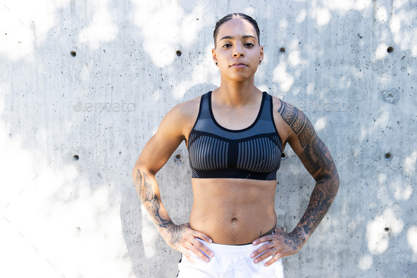 Strong, athletic African American woman with tattoos wearing athletic clothes to work out