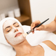 Aesthetics applying a mask to the face of a Middle-aged woman in modern wellness center. - PhotoDune Item for Sale
