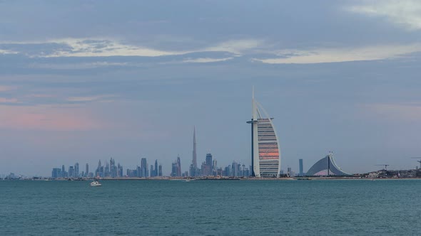 Dubai Skyline with Burj Al Arab Hotel During Sunset and Day to Night Timelapse alt