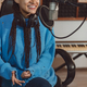 Beautiful toothy smile talking into microphone in the broadcasting and music recording studio - PhotoDune Item for Sale