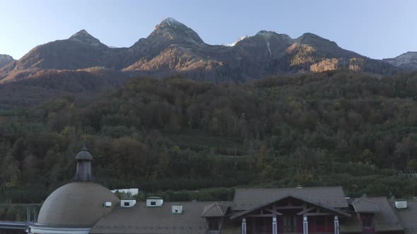 Aerial View Tracking Shot Panorama Building Roofs Natural Amazing Mountain Ridge Sunrise Scenery alt