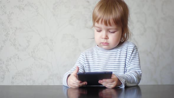 Funny Child Holding a Tablet and Tapping on Tablet Screen