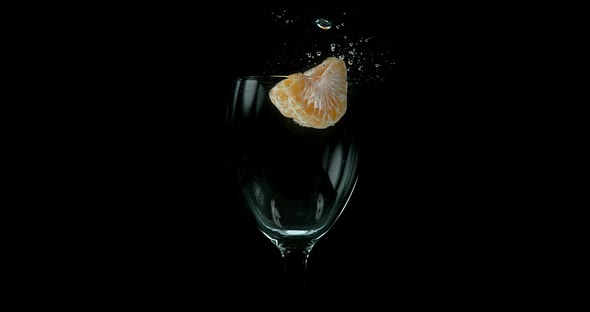 Clementines, citrus reticulata, Fruit falling into Water against black Background, Slow Motion 4K alt