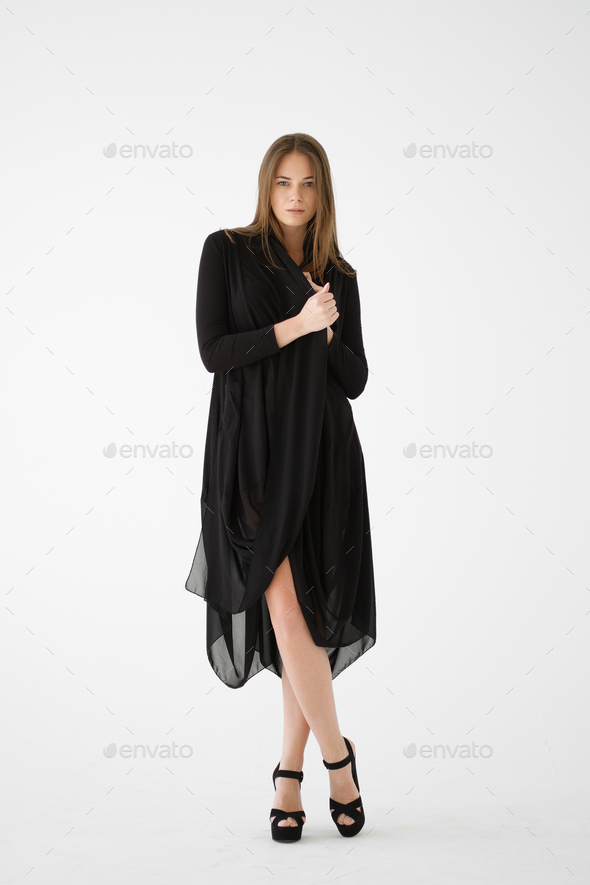 Attractive young lady in black underwear, high heele shoes and transparent dressing gown posing.