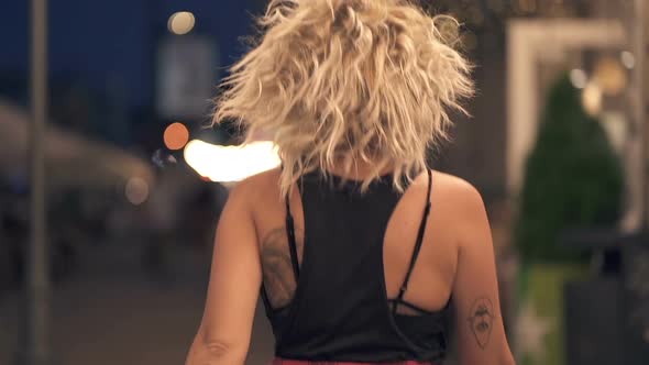 Happy curly hair woman walking at the evening street.