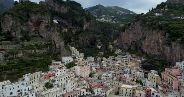 Fly Over Dramatic Townscape Of Amalfi Behind Sheer Rocky Mountains In Campania, Italy. Aerial Drone alt