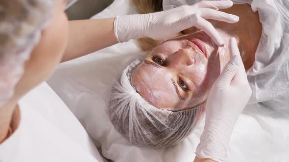 Doctor Applies an Anesthetic Cream on the Face of His Patient Lying