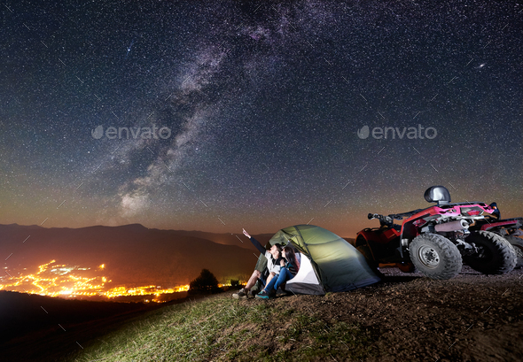Couple tourists with atv quad bike under night starry sky