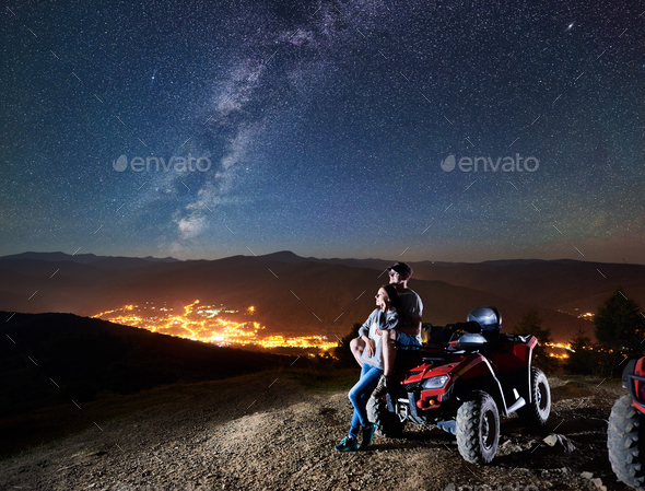 Couple tourists with atv quad bike under night starry sky
