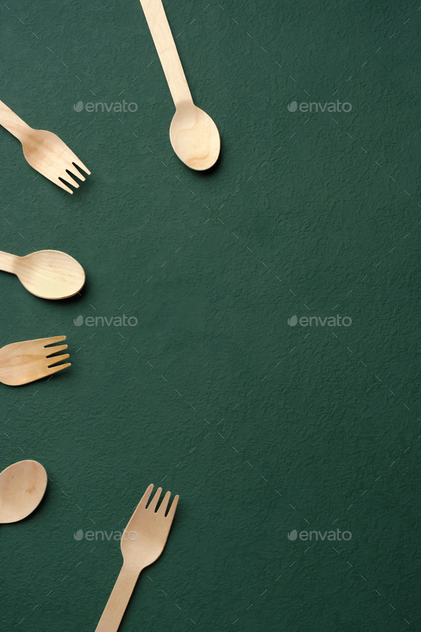 Plastic free set bamboo spoon and fork on dark green background.Zero waste disposable kitchen ware