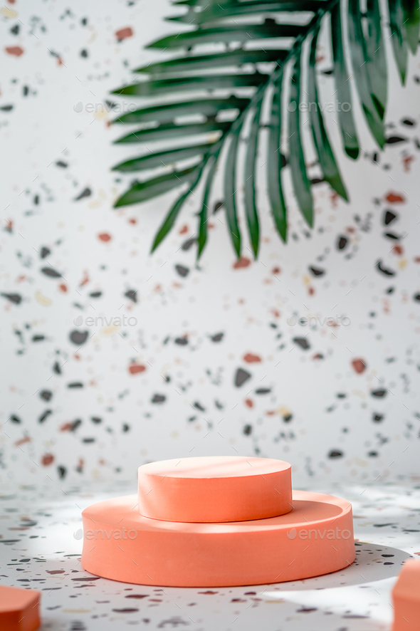 peach geometric pedestal on terrazzo background with summer sunlight and green palm leaf