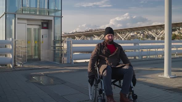 Man with Physical Disability and Paraplegia is Moving By Wheelchair in City alt